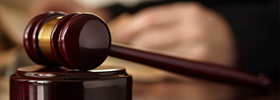 Close-up of a wooden gavel resting on its sound block